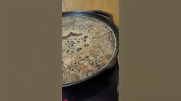 Cooking dinner in cast iron pan with portable induction cooktop.
